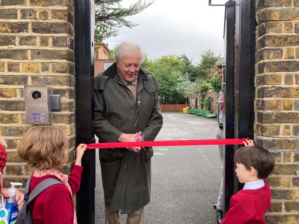 man cutting ribbon