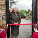 man cutting ribbon