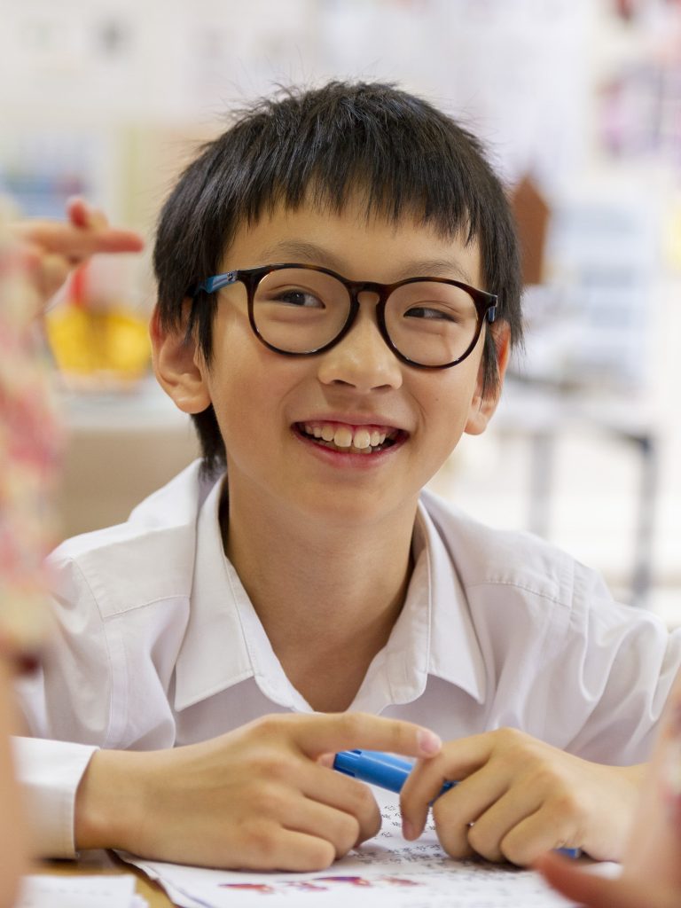 smiling student holding a pen