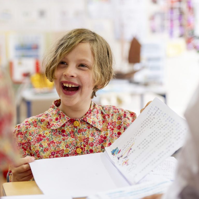 smiling student with booklet open