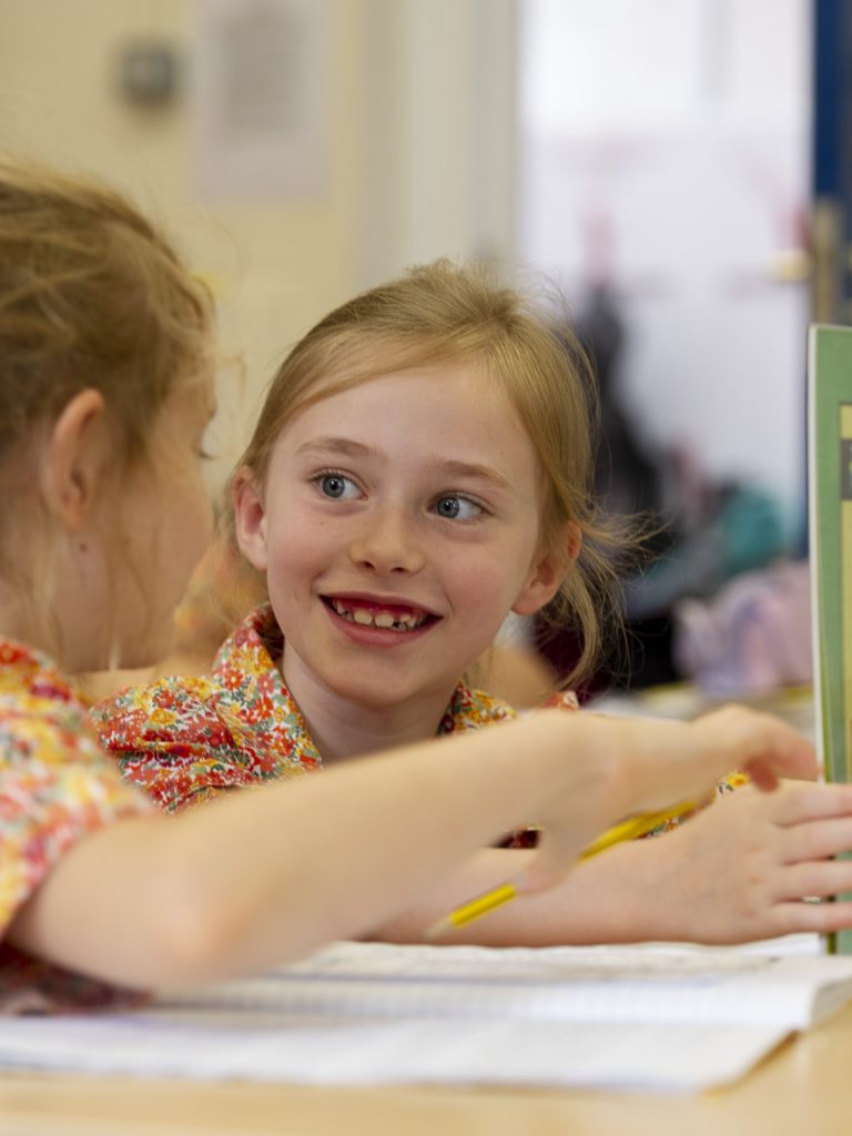 2 girls reading a book