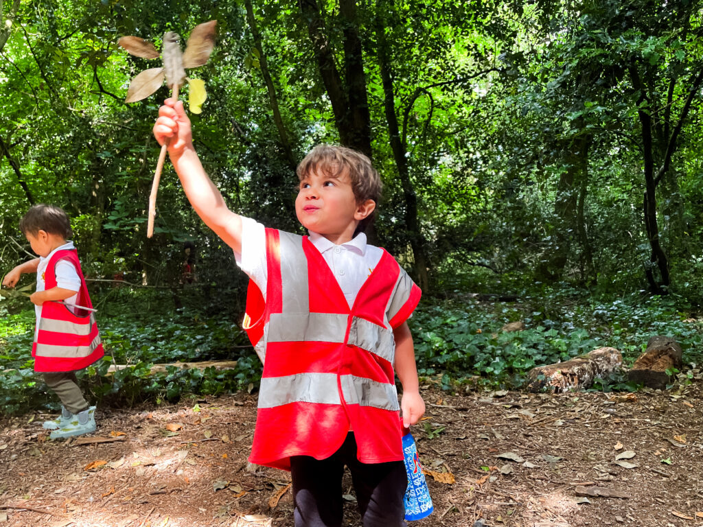 Reception child exploring nature during Forest School at Holland Park Ecology Centre